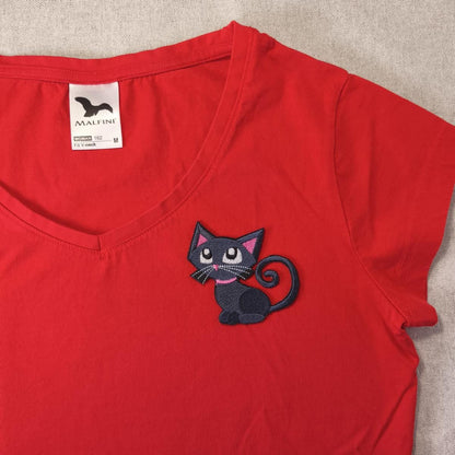 Rotes V-Ausschnitt-T-Shirt mit einem schwarzen Katzenaufnäher. Der Katzenaufnäher hat einen rosa Kragen und Schnurrhaare.