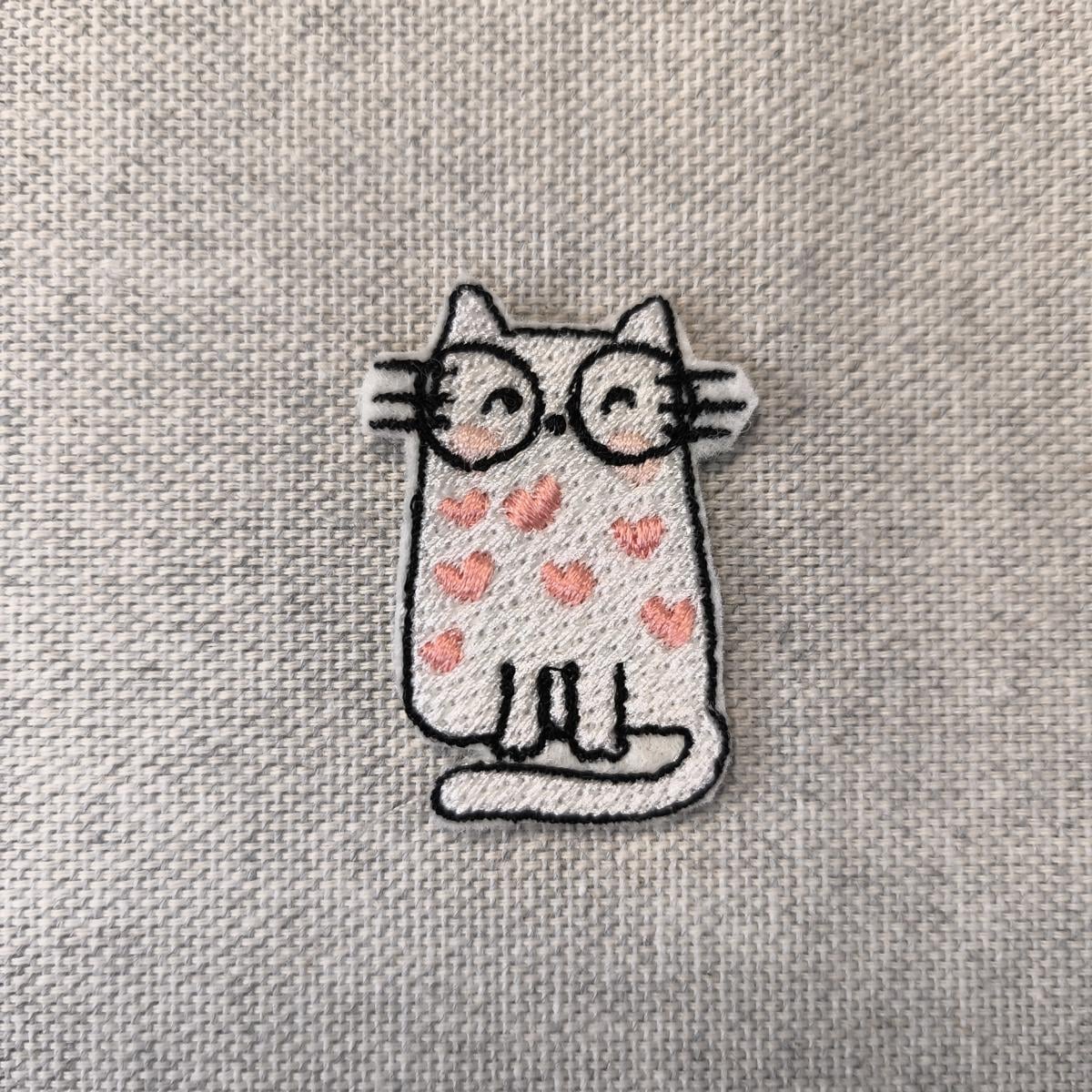 Eine Nahaufnahme des Herzen-Katze Aufnähers.