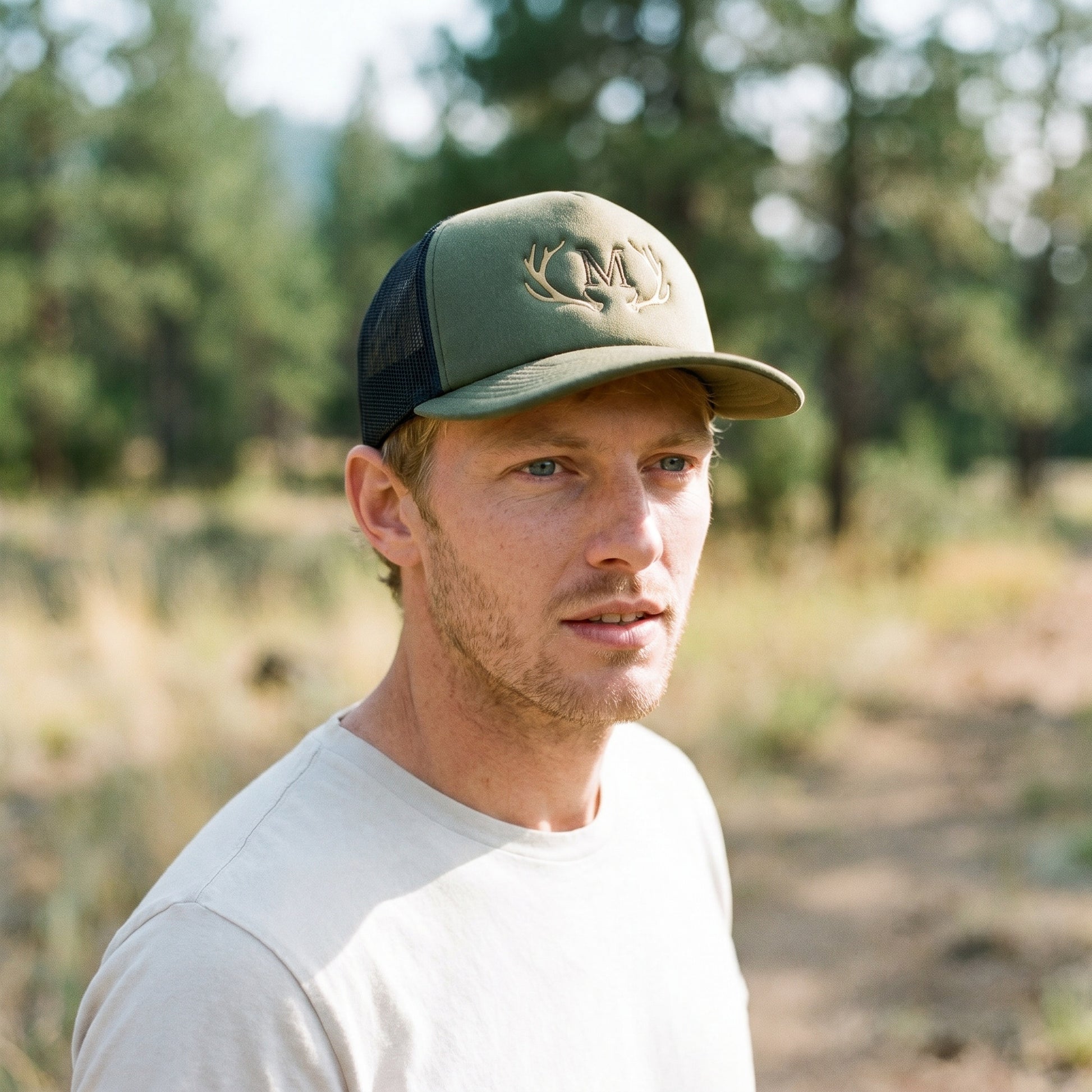 Olivgrünes Trucker Cap auf einem männlichen Modell in der Natur