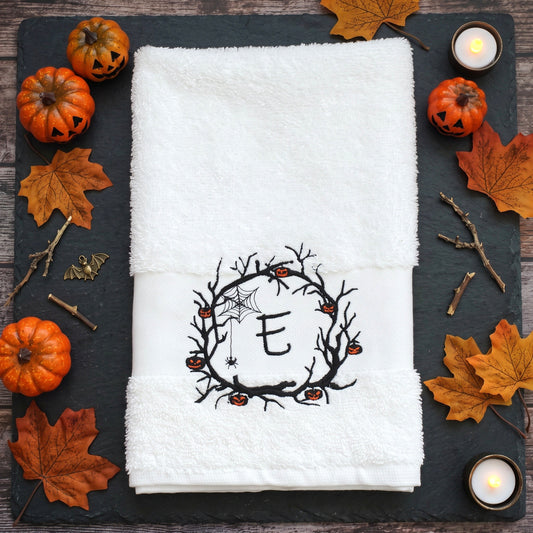 Personalisiertes weißes Handtuch mit bestickter Initiale E im Halloween Spuk-Kranz und brennender Kerze