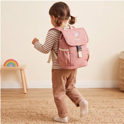 Kleines Mädchen von hinten in einer Bewegung mit dem rosa bestickten Kinderrucksack Vivien auf dem Rücken.