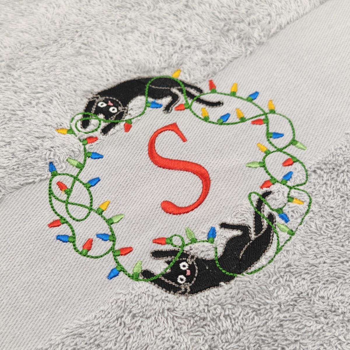 Nahaufnahme der Katzen Lichterkette mit einem roten S Stickerei um die Qualität zu zeigen.