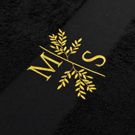 Detail Stickerei Initialen mit Blumenmotiv auf personalisiertem schwarzem Handtuch