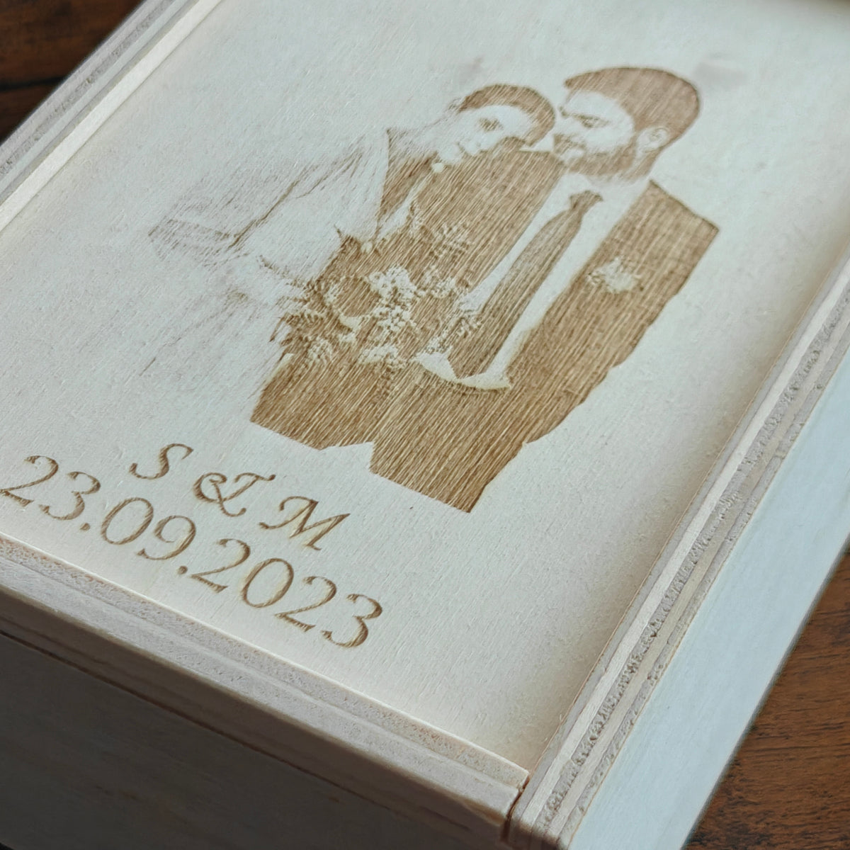 Eine Nahaufnahme der personalisierten Pappel-Holz-Geschenkbox - mit Foto, Initialen und Datum graviert.